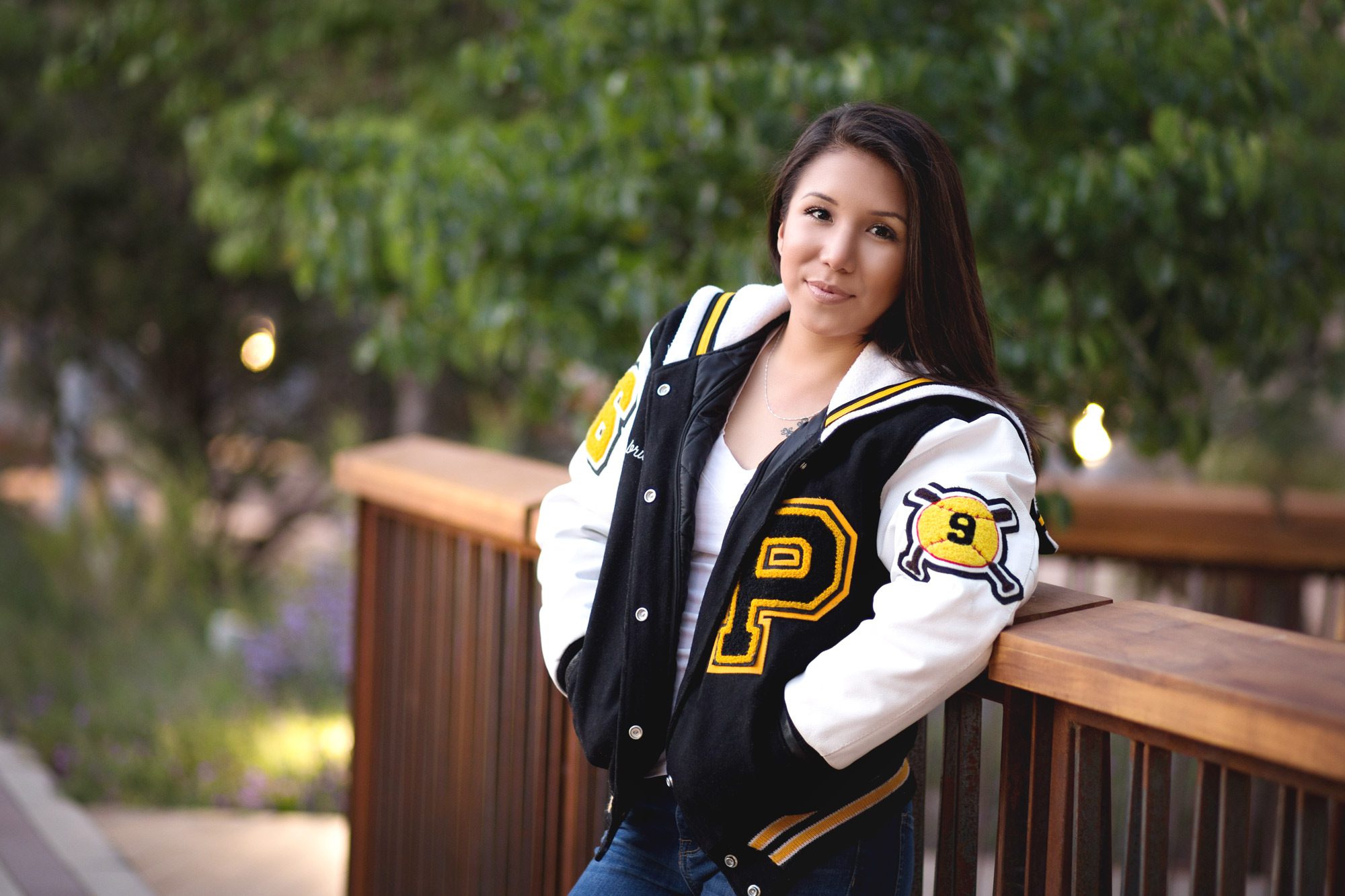 Parkland high senior girl sports her softball letterman jacket during senior pictures